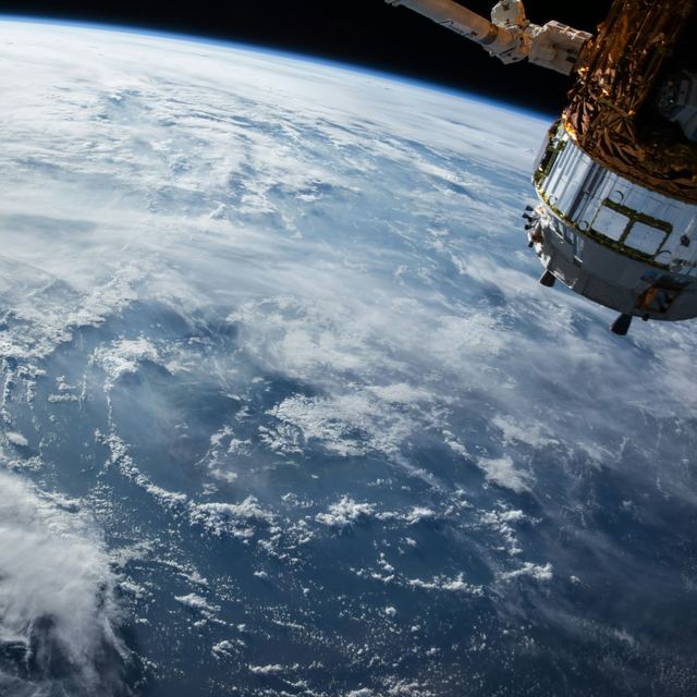 Earth seen from space with a satellite in the foreground